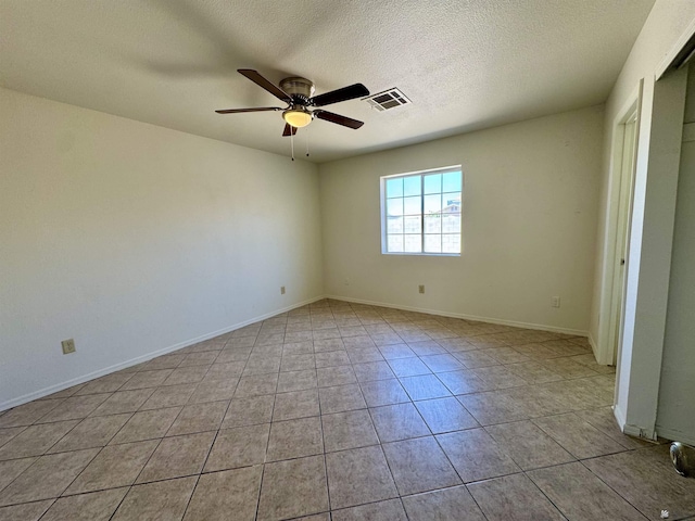 unfurnished room with visible vents, light tile patterned flooring, baseboards, ceiling fan, and a textured ceiling