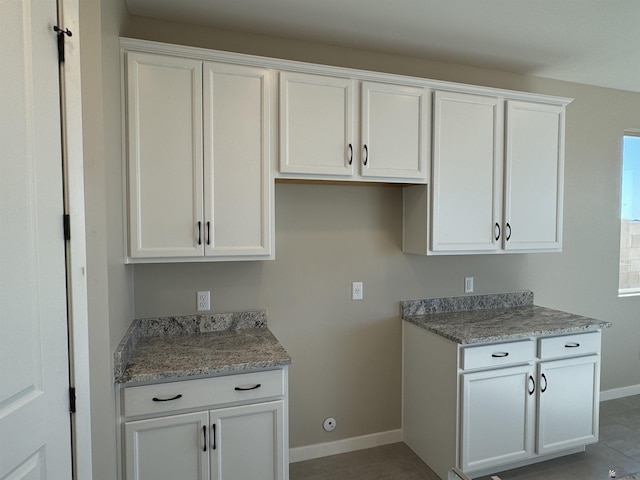 kitchen featuring tile patterned flooring and white cabinetry