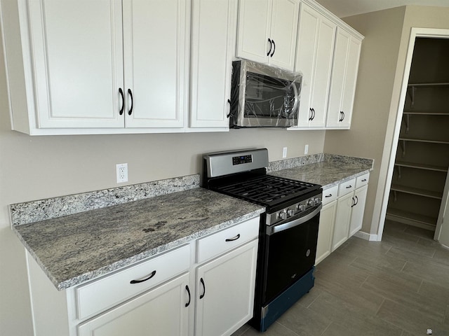 kitchen with white cabinets, appliances with stainless steel finishes, and light stone counters