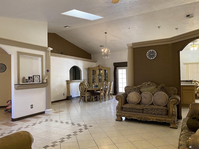 living area featuring light tile patterned floors, arched walkways, a ceiling fan, and lofted ceiling with skylight