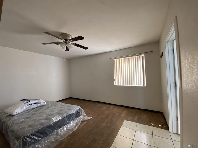 bedroom with baseboards, ceiling fan, and wood finished floors