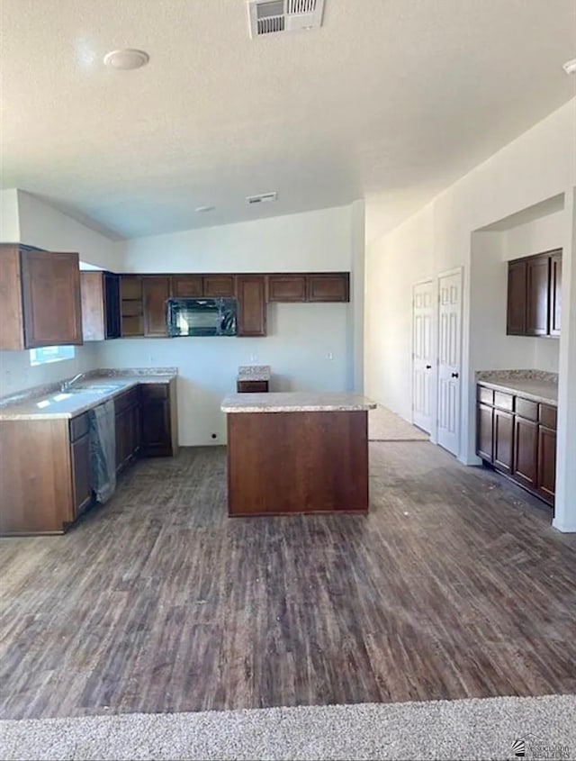 7903 E 46th Ln, Yuma, AZ 85365 - kitchen featuring dark wood-type flooring, black microwave, a textured ceiling, a kitchen island, and dark brown cabinetry