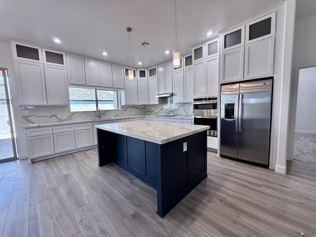 12360 E Calle Ln, Primera, Yuma, AZ 85367 - kitchen featuring a sink, light wood-style flooring, stainless steel appliances, tasteful backsplash, and a kitchen island