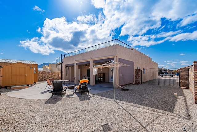 14326 E 51st St, Yuma, AZ 85367 - back of house with a storage shed, a gate, a patio area, fence, and stucco siding