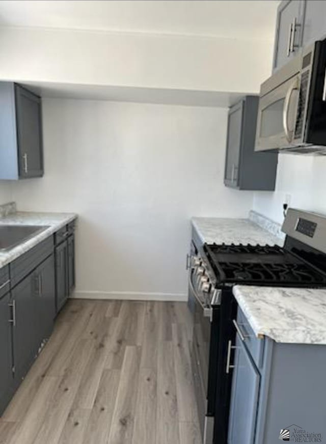 584 S S Ave Unit B, Yuma, AZ 85364 - kitchen featuring gray cabinets, a sink, light wood finished floors, and stainless steel appliances