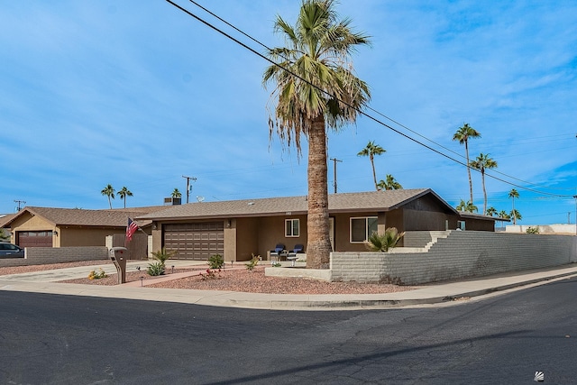 single story home featuring a garage, fence, concrete driveway, a shingled roof, and stucco siding