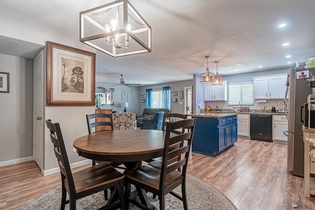 dining space featuring light wood-type flooring, recessed lighting, baseboards, and ceiling fan with notable chandelier