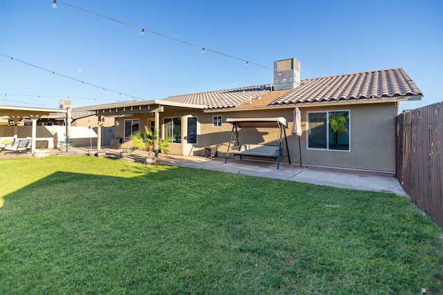 back of house with a patio area, a chimney, stucco siding, and a tiled roof