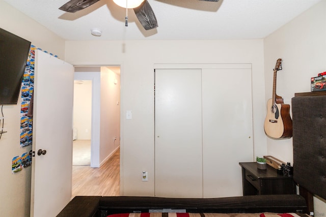 bedroom with light wood-style floors, a closet, and ceiling fan