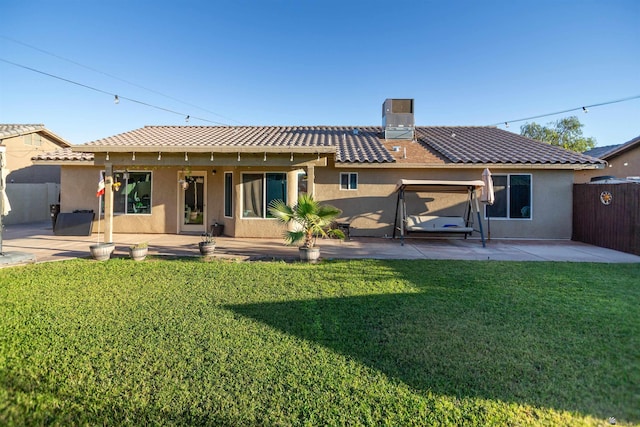 rear view of property featuring a patio area, a tile roof, stucco siding, and a chimney