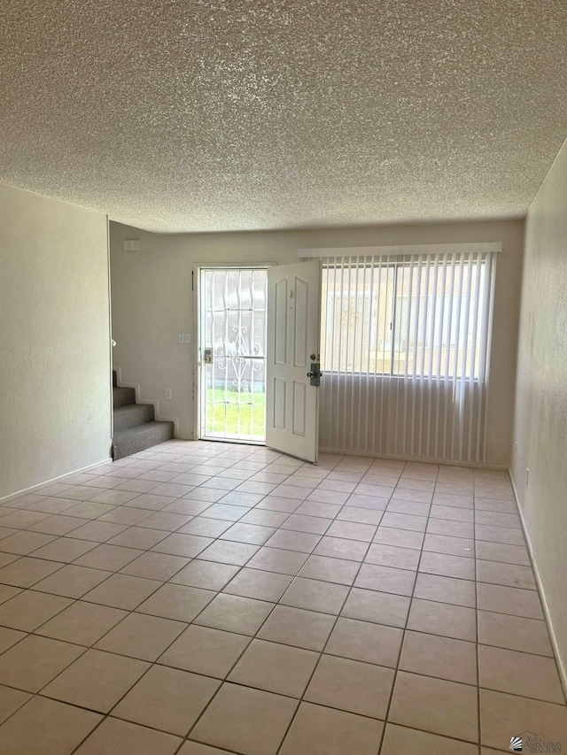 1234 W 20th Pl, Yuma, AZ 85364 - empty room with stairway, a textured ceiling, and light tile patterned floors