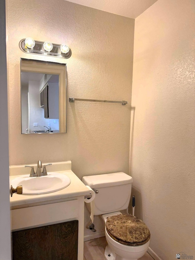 1234 W 20th Pl, Yuma, AZ 85364 - bathroom with toilet, vanity, baseboards, and a textured wall