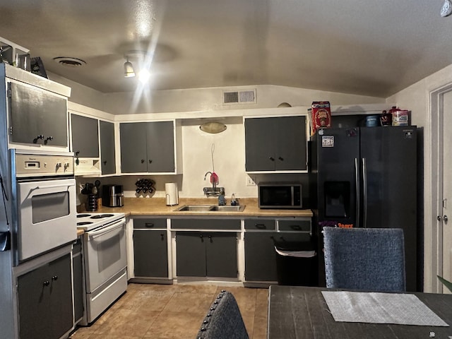 kitchen with a sink, stainless steel microwave, white electric range oven, black fridge, and oven