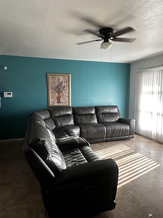 living room with a ceiling fan and a textured ceiling