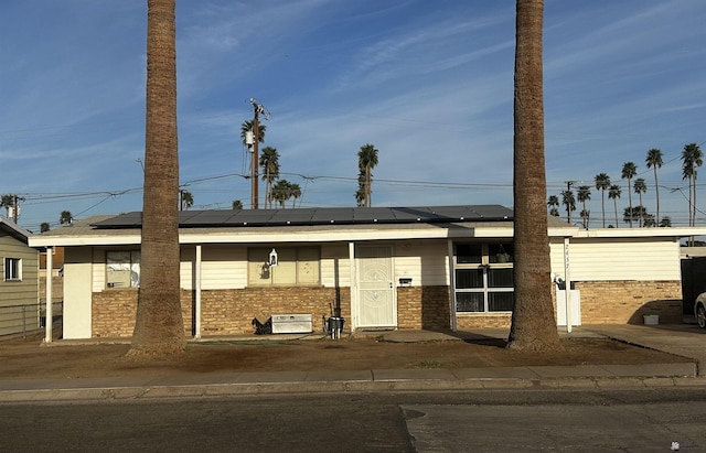 view of front of property with solar panels and brick siding