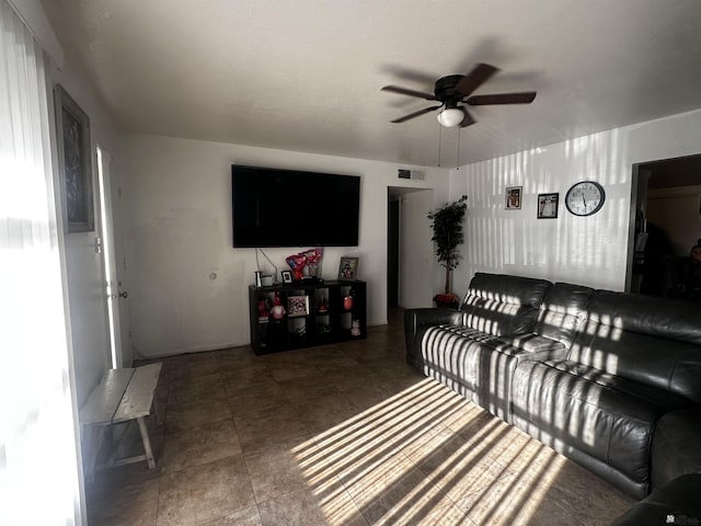 living room with ceiling fan, visible vents, and tile patterned floors