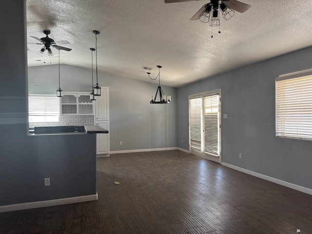 10310 E 37th Pl, Yuma, AZ 85365 - unfurnished living room with a ceiling fan, a textured ceiling, vaulted ceiling, and dark wood-style floors
