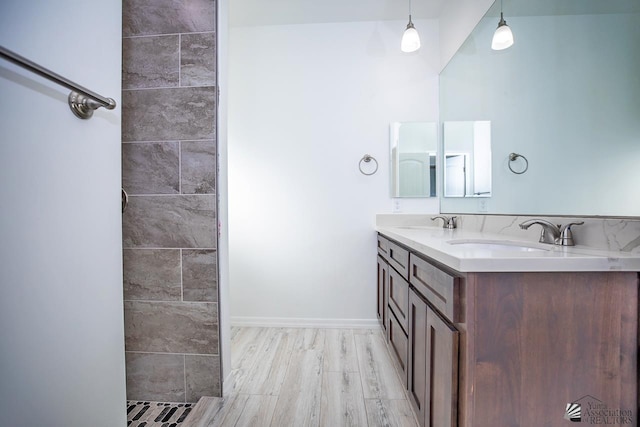 full bathroom featuring double vanity, a sink, and wood finished floors