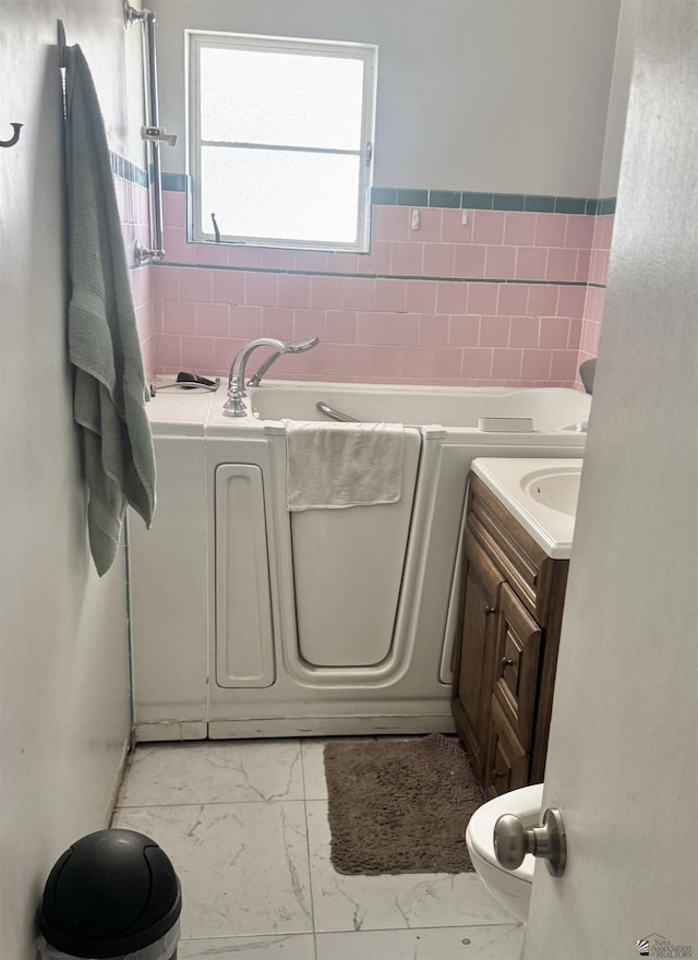 2681 S Walnut Ave, Yuma, AZ 85364 - full bath featuring marble finish floors, a bath, vanity, and tile walls