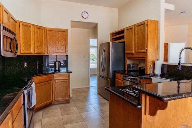 10453 S Del Rico, Yuma, AZ 85367 - kitchen with brown cabinetry, decorative backsplash, appliances with stainless steel finishes, and a peninsula
