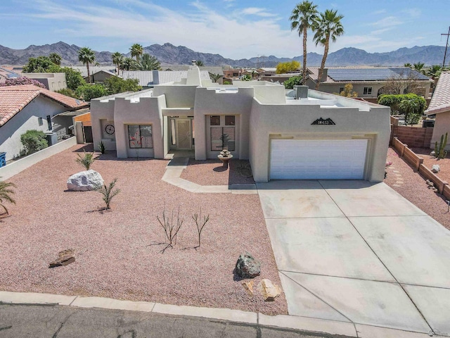 10453 S Del Rico, Yuma, AZ 85367 - pueblo-style home featuring stucco siding, an attached garage, a mountain view, and concrete driveway