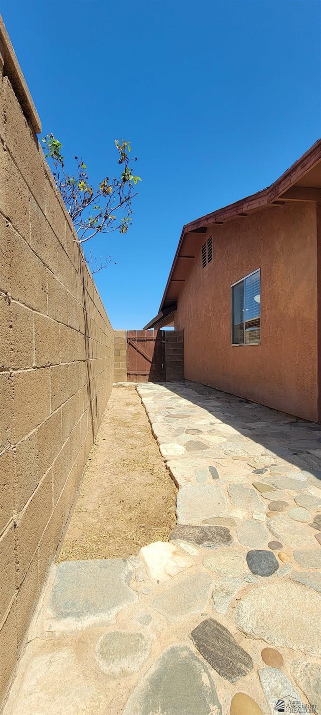 view of property exterior with a patio, fence, and stucco siding