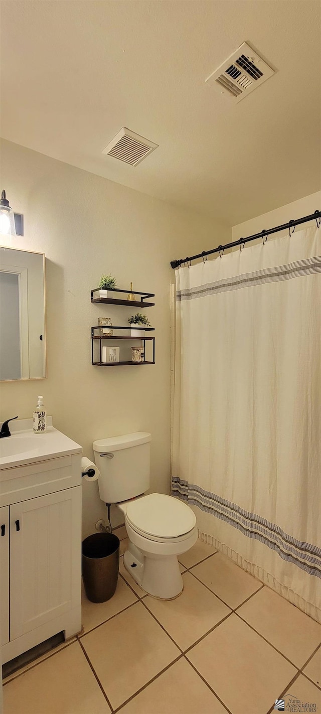bathroom featuring toilet, visible vents, tile patterned flooring, and vanity