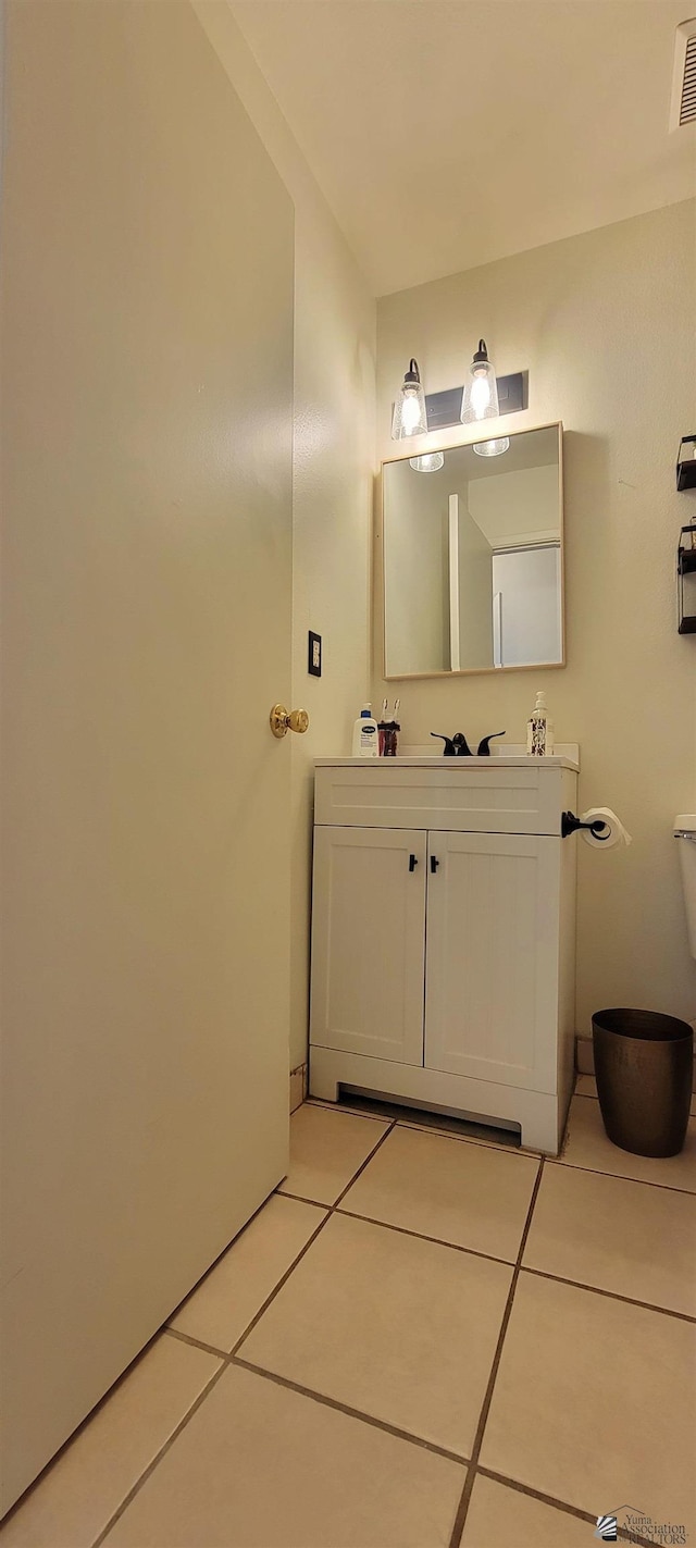 bathroom featuring tile patterned flooring, toilet, and vanity