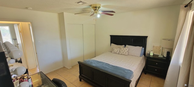 bedroom featuring light tile patterned floors, a ceiling fan, a closet, and visible vents