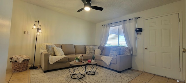 living room with light tile patterned floors, a ceiling fan, a textured ceiling, and lofted ceiling