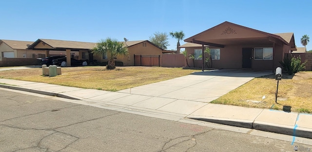 single story home featuring an attached carport, fence, a front yard, and concrete driveway