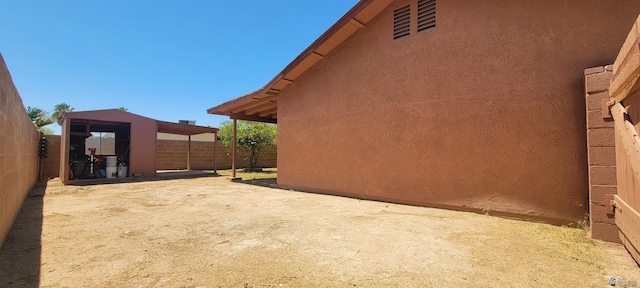 view of property exterior with a patio, stucco siding, and fence