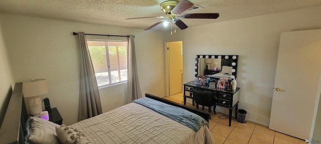 bedroom with light tile patterned floors, a ceiling fan, and a textured ceiling