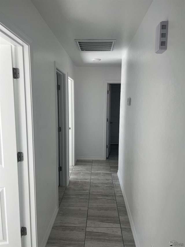 hallway featuring dark tile patterned flooring