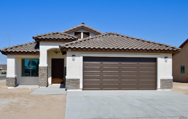 mediterranean / spanish-style house with a garage