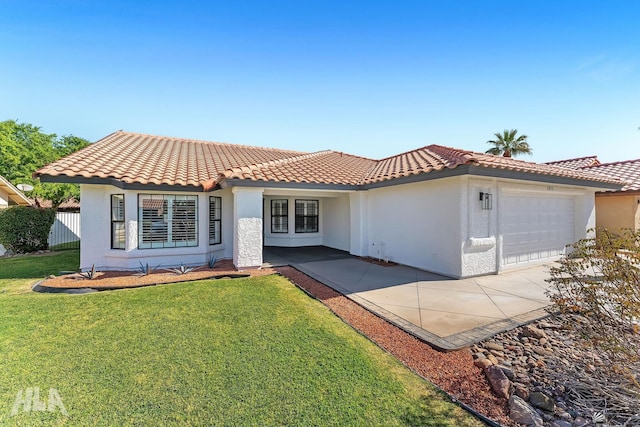2032 W 13th Ln, Yuma, AZ 85364 - mediterranean / spanish house with an attached garage, stucco siding, a tiled roof, and concrete driveway