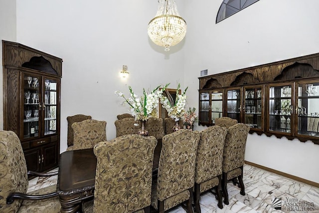 1376 S Hettema St, Yuma, AZ 85364 - dining room with marble finish flooring, a chandelier, a high ceiling, and baseboards