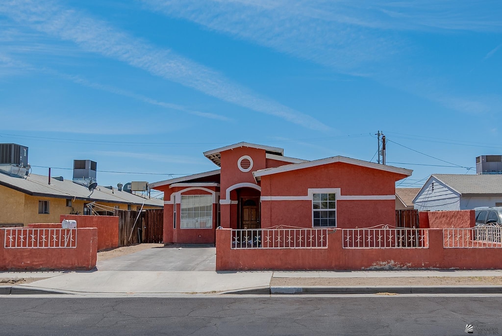 2320 S Maple Ave, Yuma, AZ 85364 - view of front of home featuring a fenced front yard, stucco siding, and central AC unit