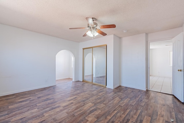 2320 S Maple Ave, Yuma, AZ 85364 - spare room featuring wood finished floors, a ceiling fan, arched walkways, a textured ceiling, and baseboards