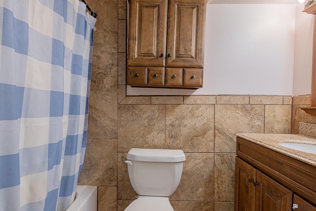1871 S Mckinley Ave, Yuma, AZ 85364 - bathroom featuring vanity, tile walls, toilet, shower / bath combo with shower curtain, and wainscoting