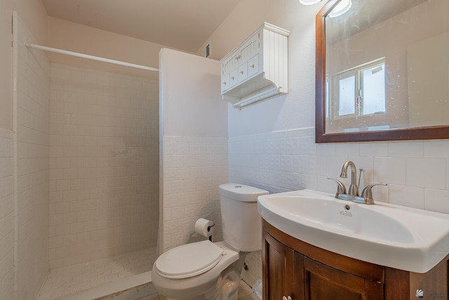 1871 S Mckinley Ave, Yuma, AZ 85364 - bathroom featuring a tile shower, toilet, vanity, tile walls, and a wainscoted wall