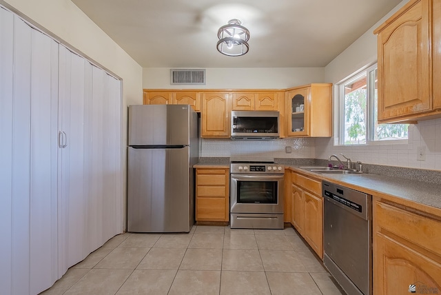 1871 S Mckinley Ave, Yuma, AZ 85364 - kitchen with appliances with stainless steel finishes, a sink, backsplash, glass insert cabinets, and light tile patterned floors