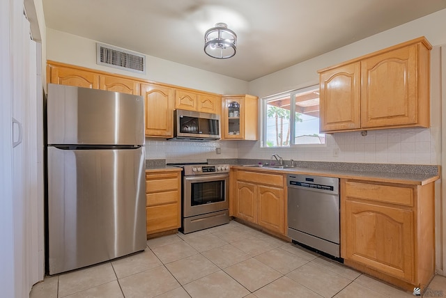 1871 S Mckinley Ave, Yuma, AZ 85364 - kitchen featuring stainless steel appliances, a sink, tasteful backsplash, and light brown cabinetry