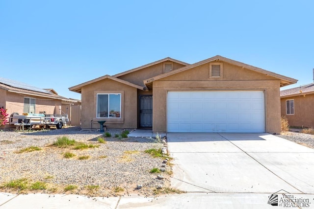 ranch-style house featuring a garage, stucco siding, and concrete driveway
