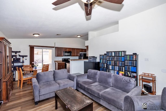 living room with light wood-type flooring, ceiling fan, lofted ceiling, and visible vents
