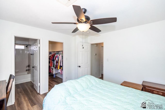 bedroom with ensuite bath, a spacious closet, visible vents, dark wood-style floors, and a closet