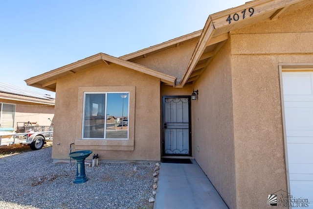 view of exterior entry featuring stucco siding