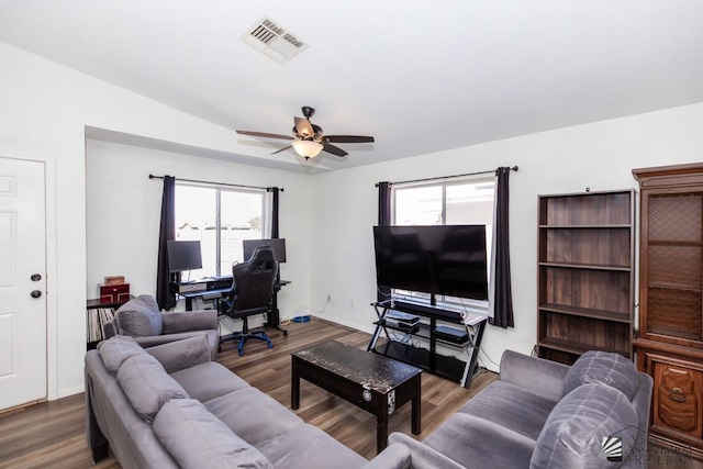 living area with a ceiling fan, visible vents, a wealth of natural light, and wood finished floors
