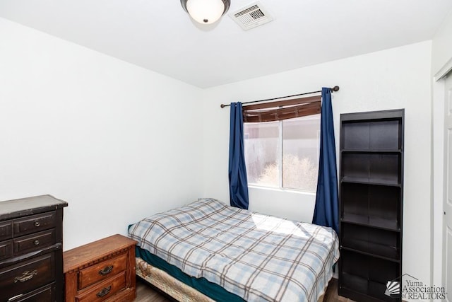 bedroom with visible vents and dark wood-type flooring