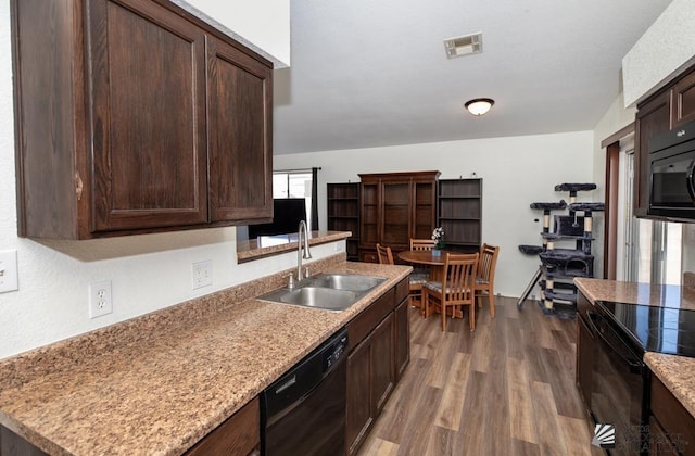 kitchen with visible vents, dark brown cabinets, a sink, black appliances, and dark wood-style floors
